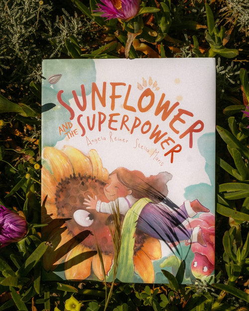 Book titled 'The Sunflower and Her Superpower' surrounded by greenery and flowers