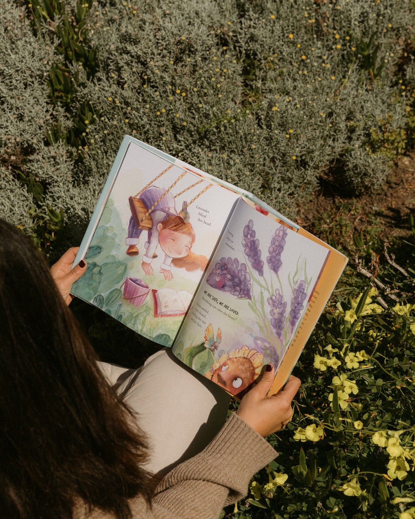 Person reading a book with illustrations of animals in a natural setting